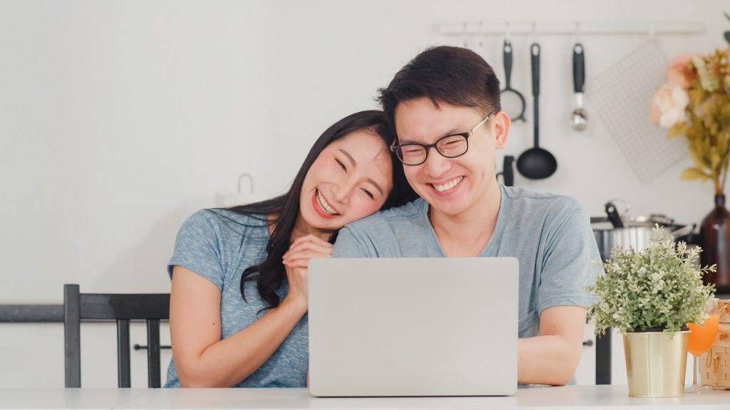 Young Asian Couple Enjoy Shopping Online On Laptop At Home. Life