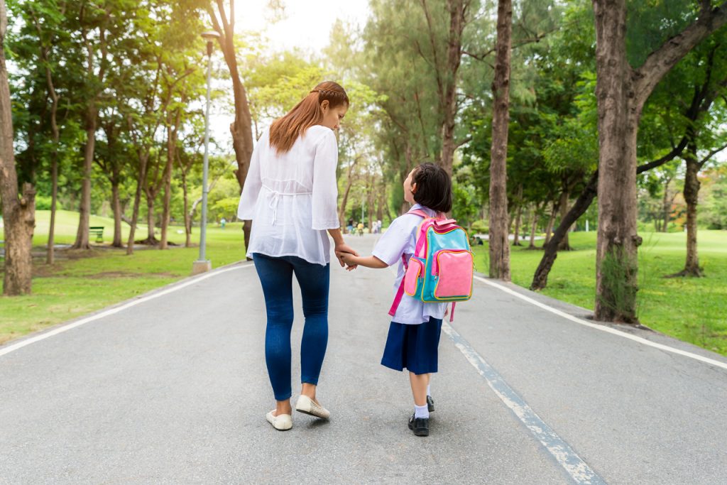 Mother and daughter walking to school